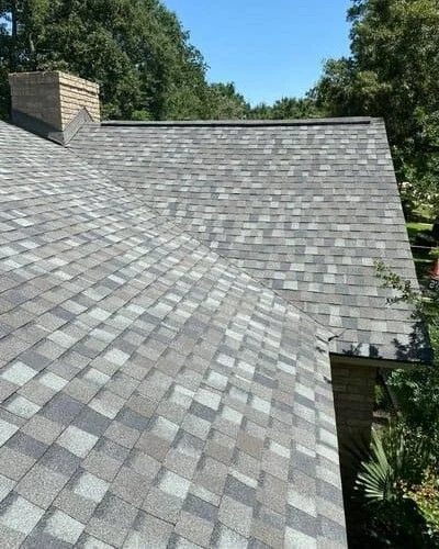 Professional roofer installing shingles on a residential roof in Sugar Land, Texas.